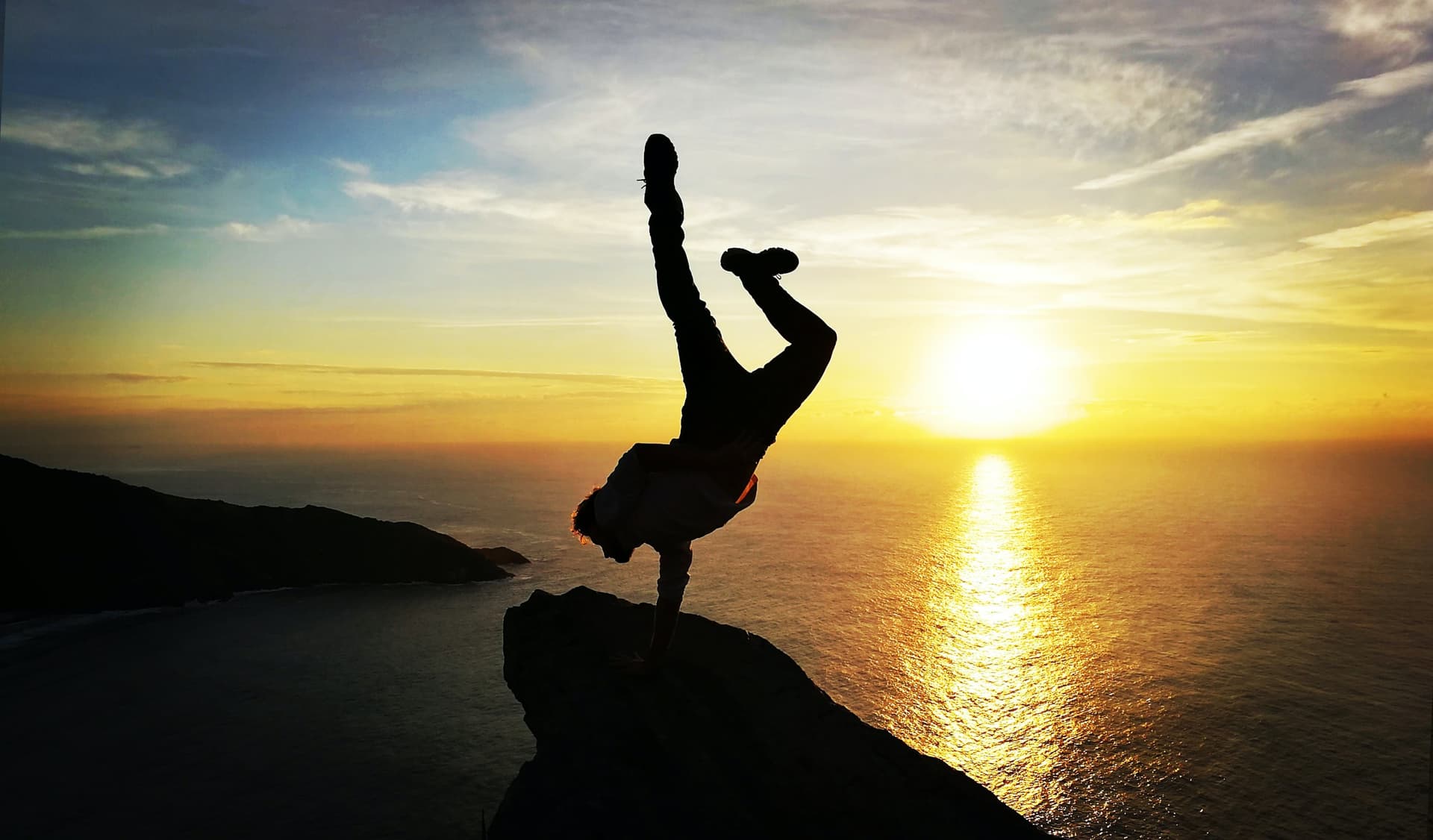 Teilnehmer macht Handstand im Sonnenuntergang