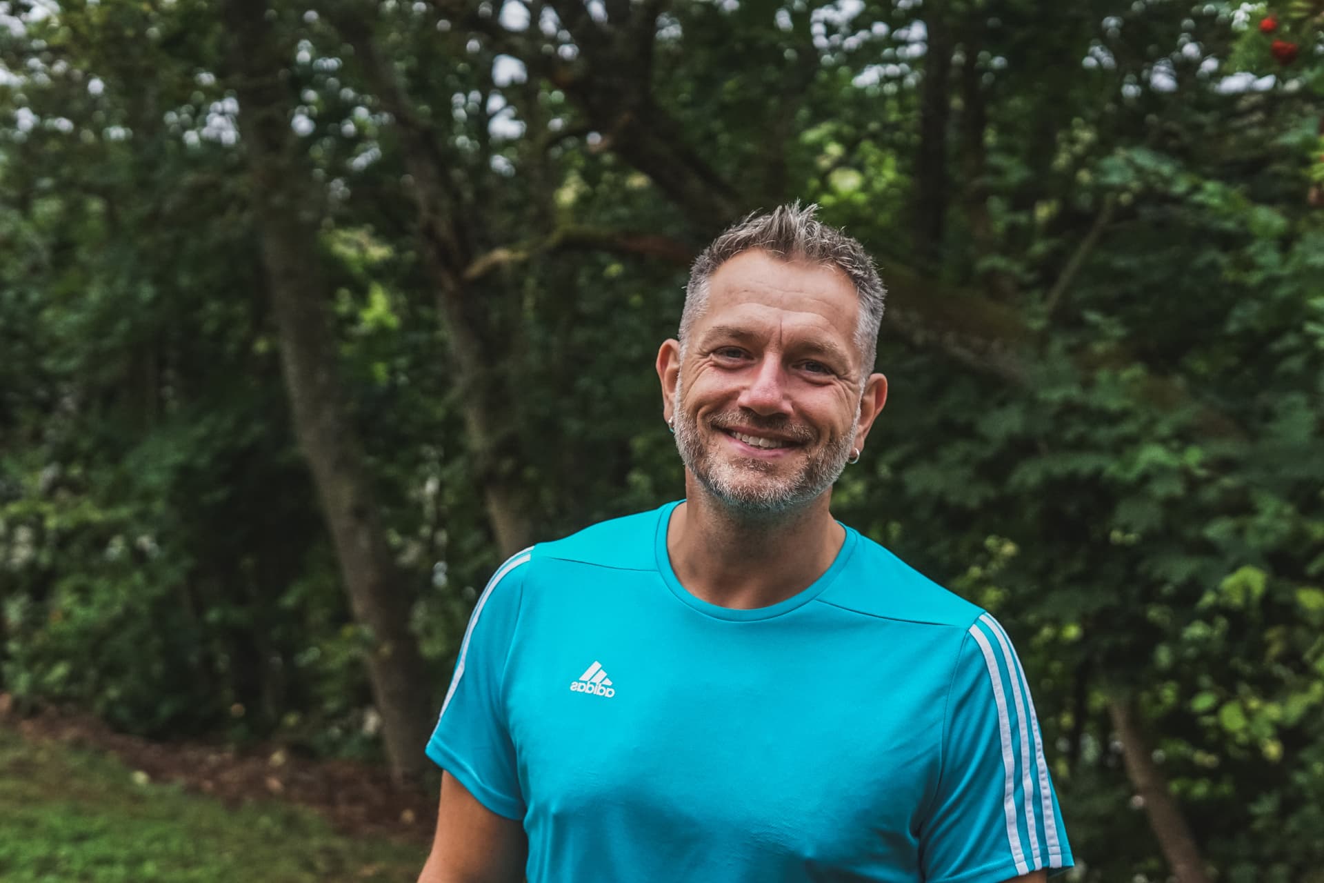 Mann im blauen Shirt vor einem Gerüst