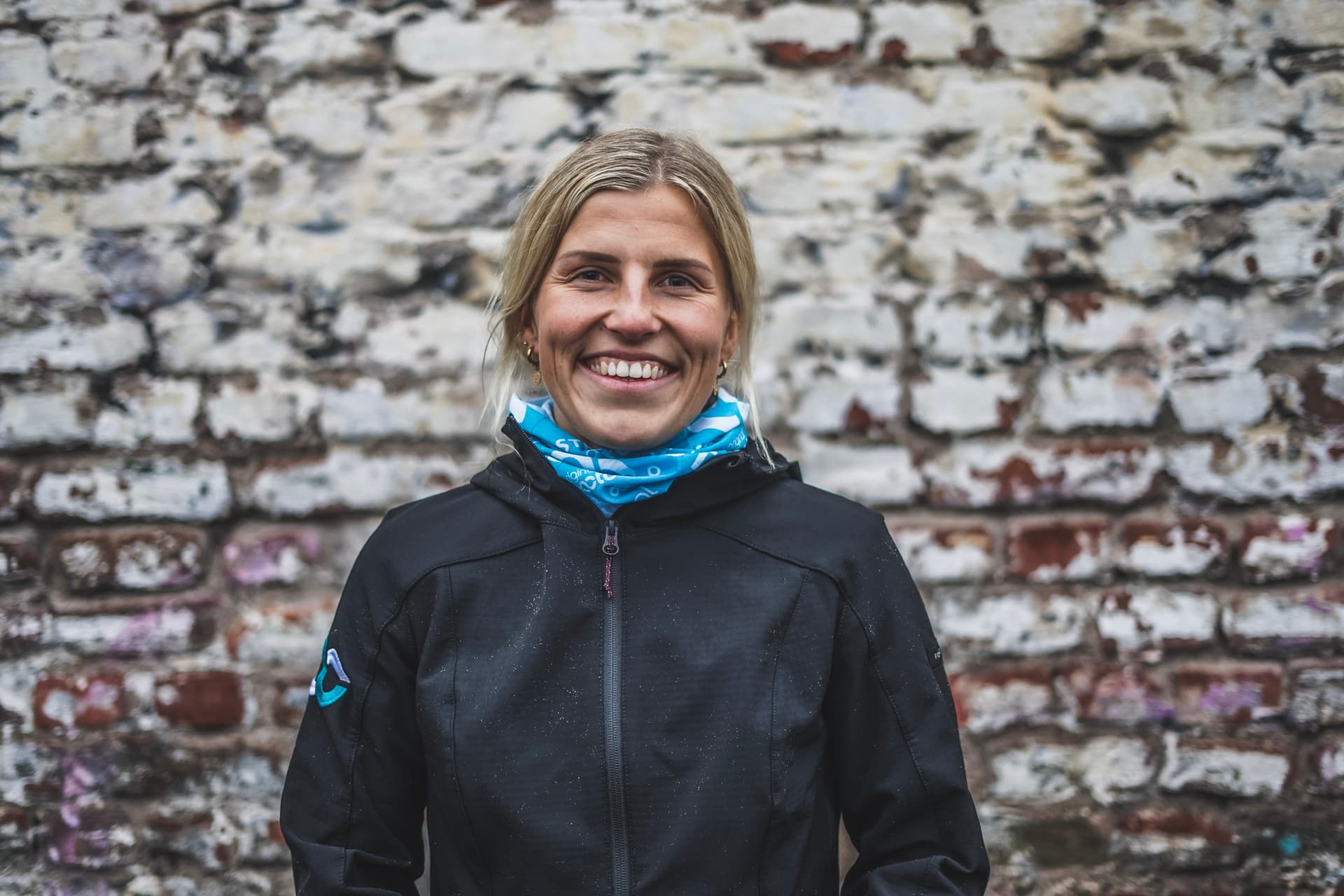 Fitness Trainerin Nina Löber lächelt und trägt eine Softshell Jacke