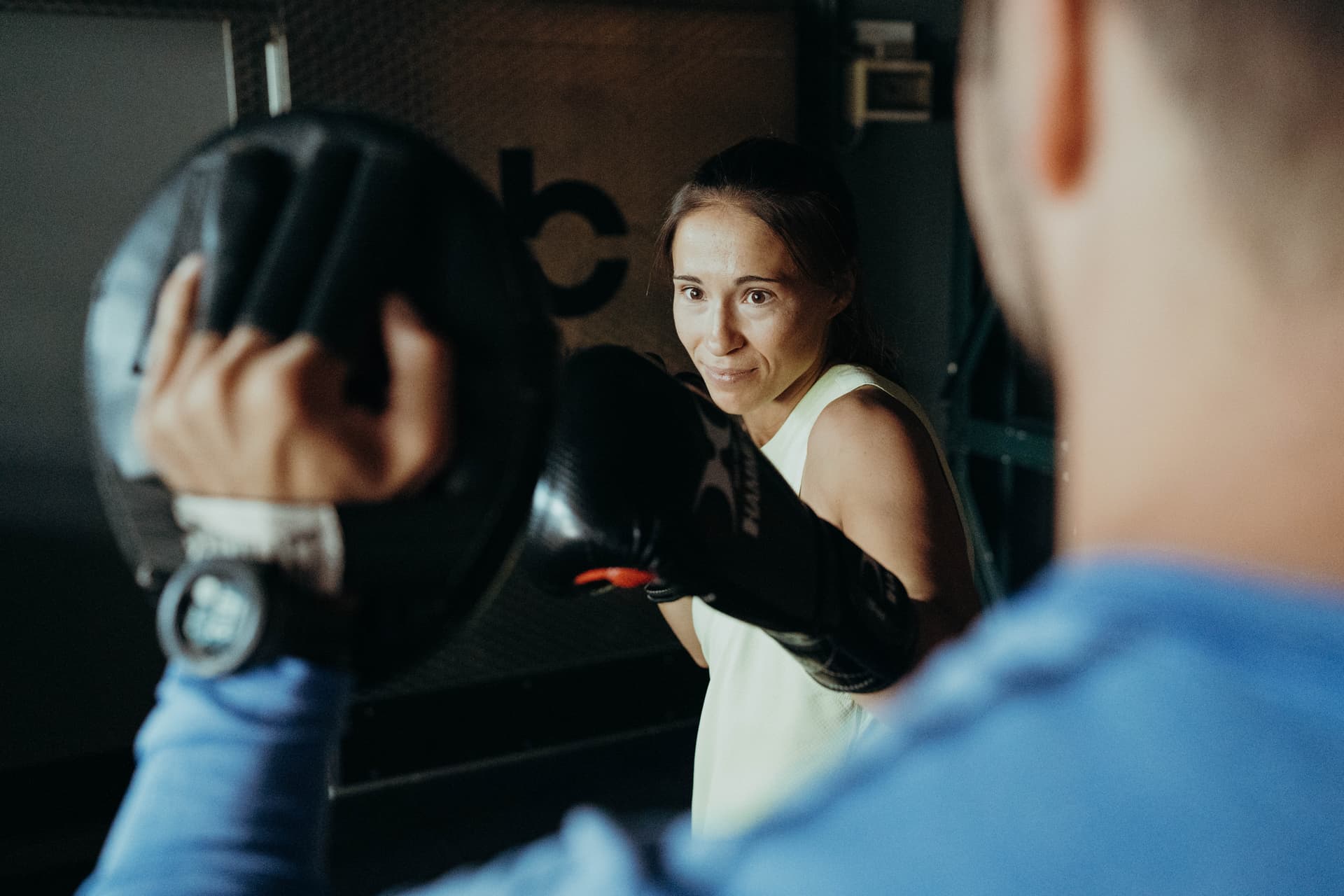 Frau die kraftvoll in eine Pratze boxt beim Reboot in Köln