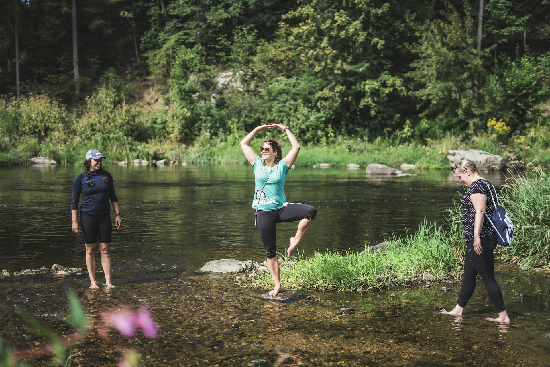 Eine Frau macht Yoga-Übungen im flachen Wasser mitten in der Natur