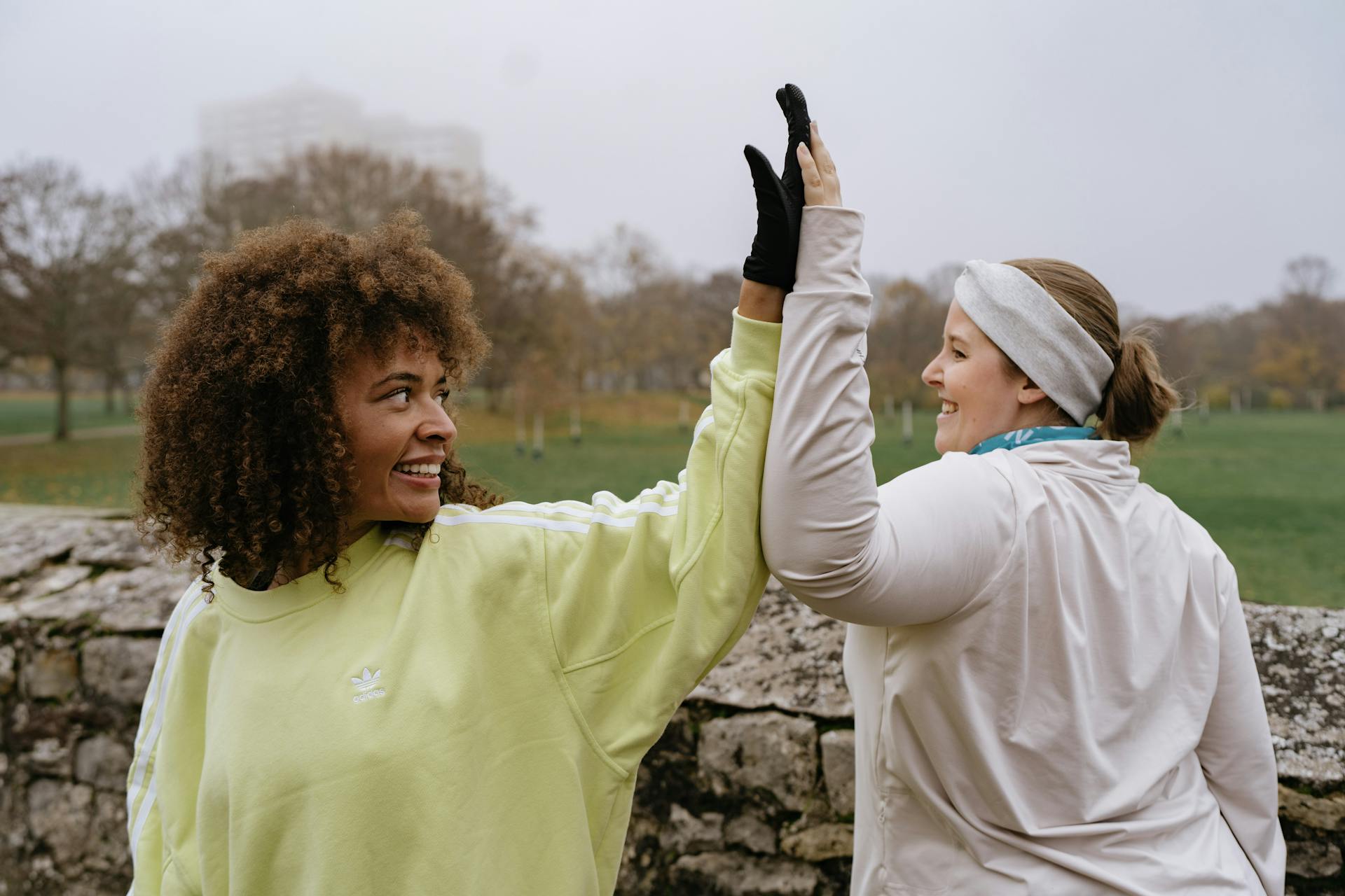 Zwei Frauen motivieren sich gegenseitig zwischen zwei Übungen mit einem Highfive