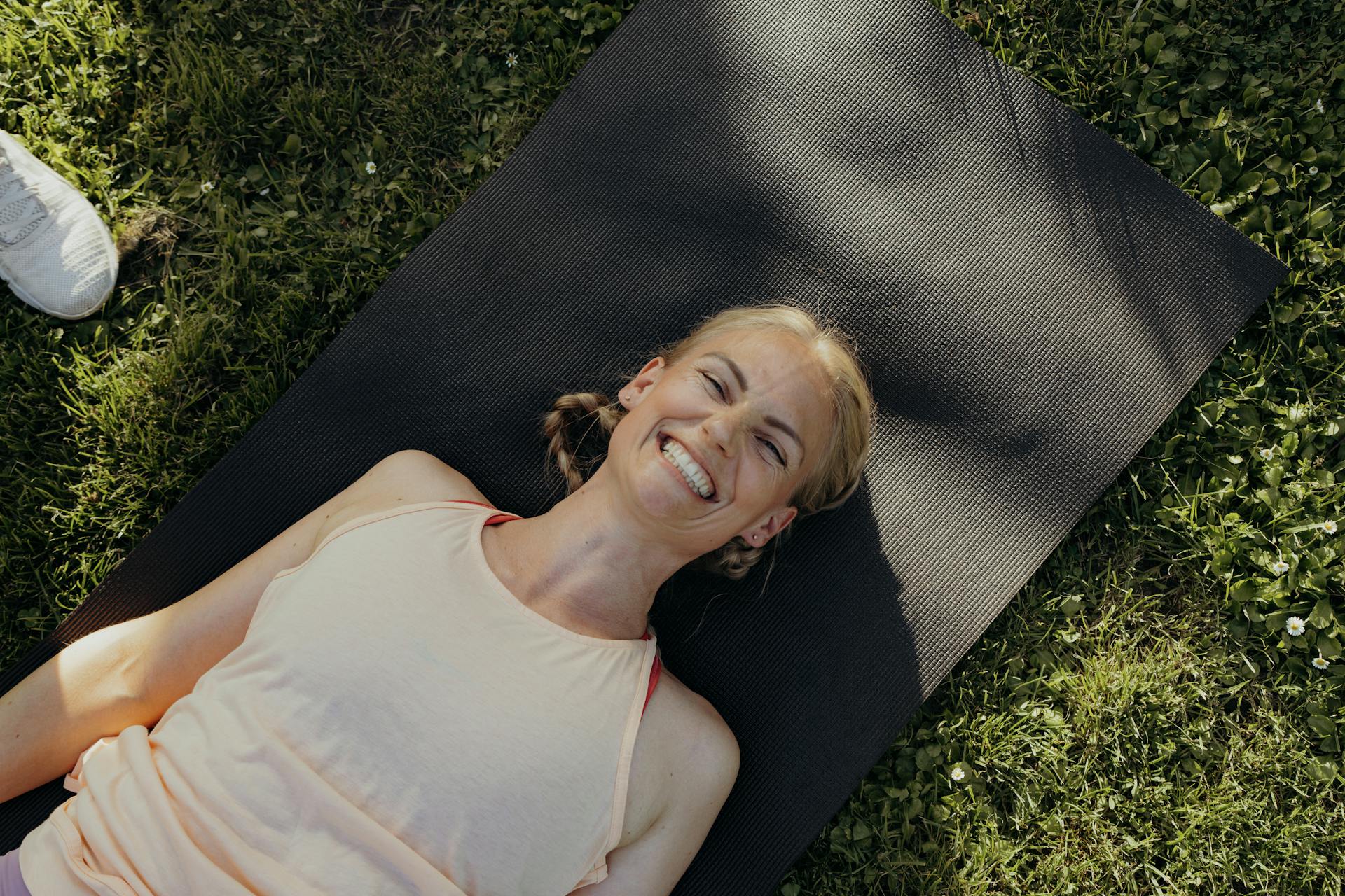Frau mit Lachen auf einer Sportmatte
