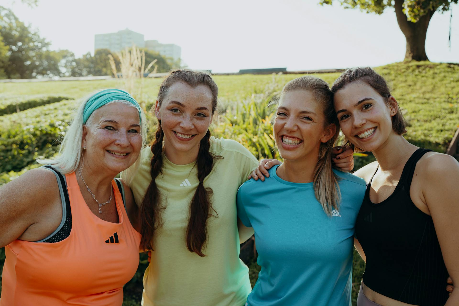 Vier Frauen gemischten Alters lächeln gemeinsam in die Kamera