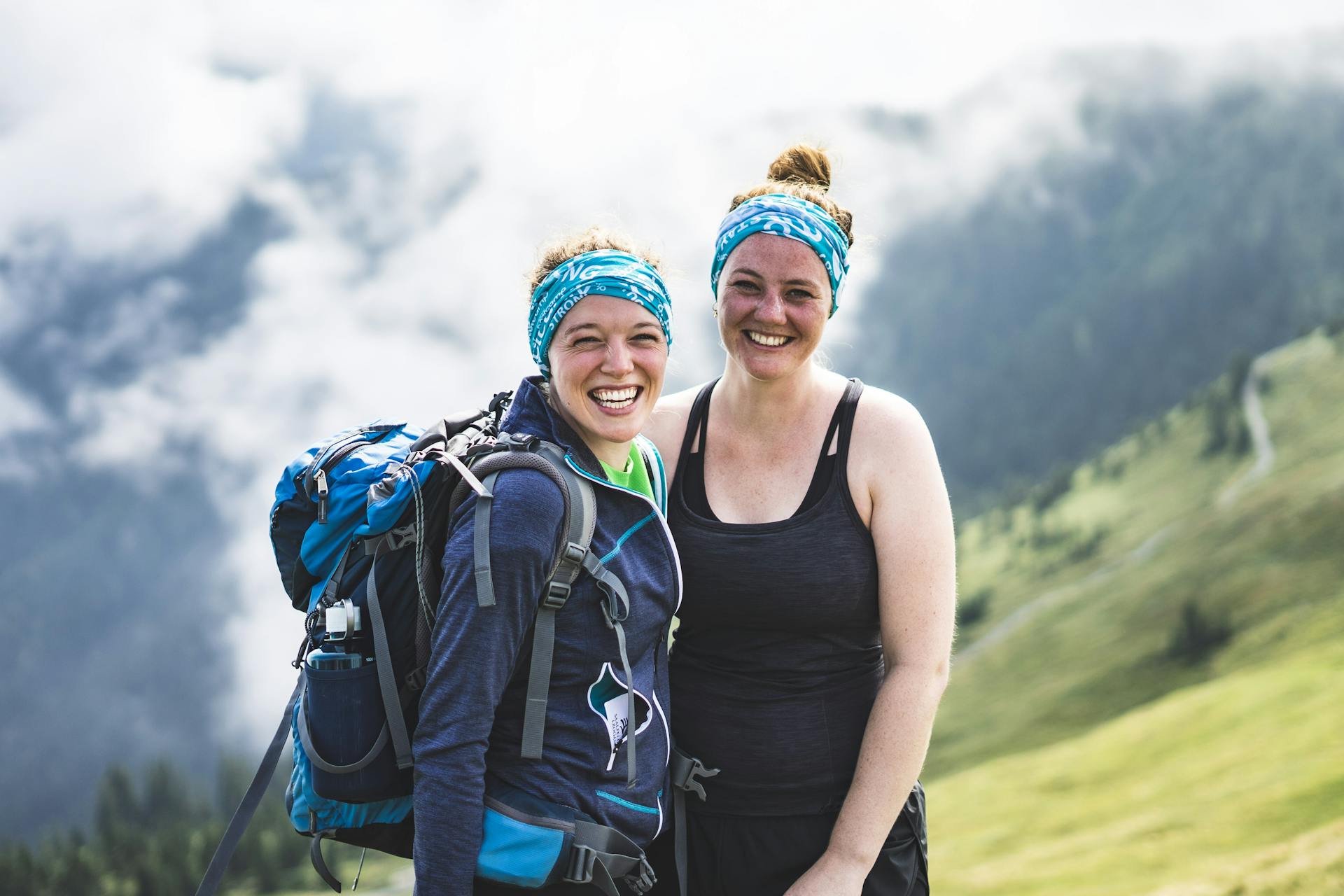 2 Frauen mit Rucksack und Sportklamotten in den Bergen