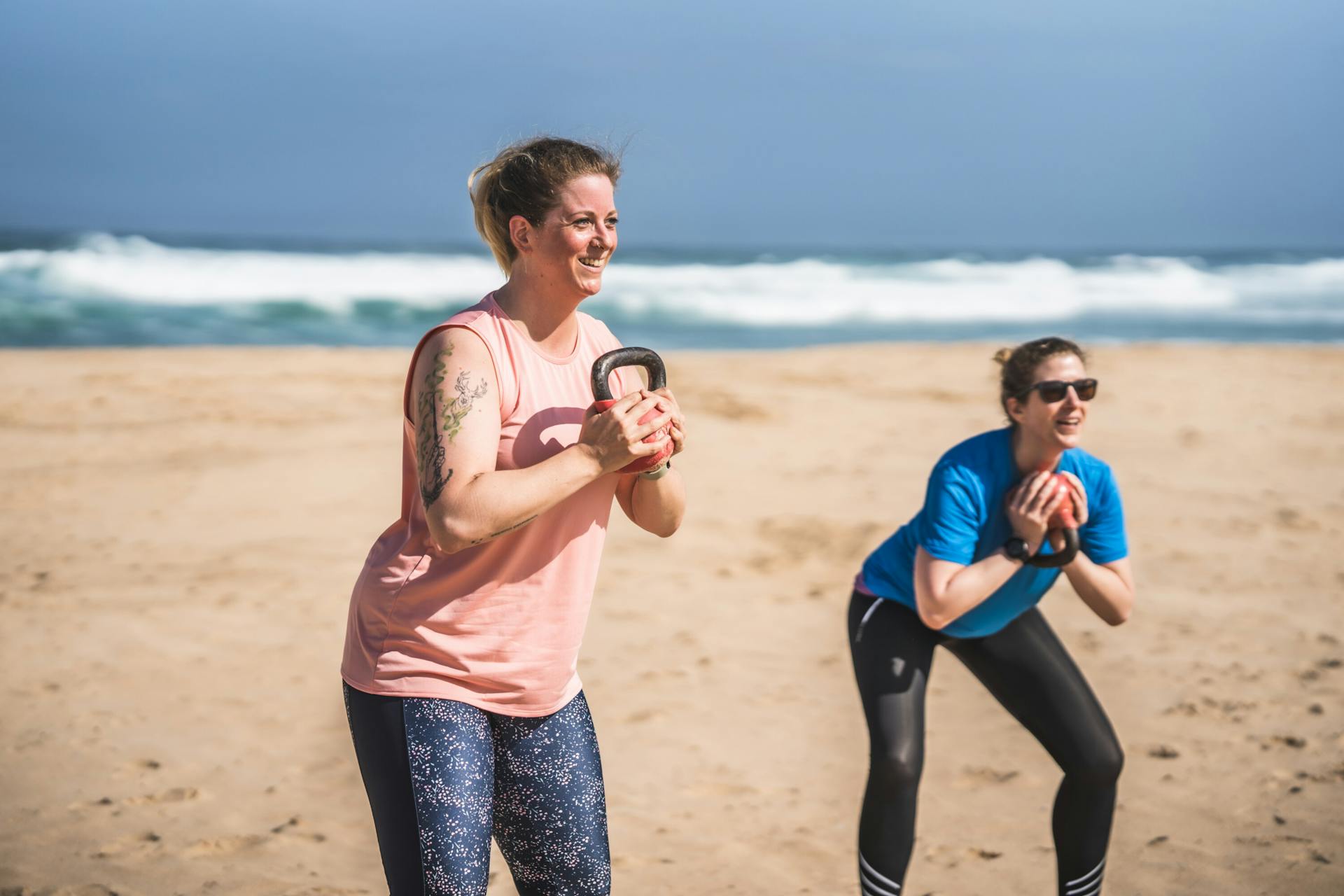Zwei Teilnehmerinnen beim Kettlebell Workout am Strand der Algarve