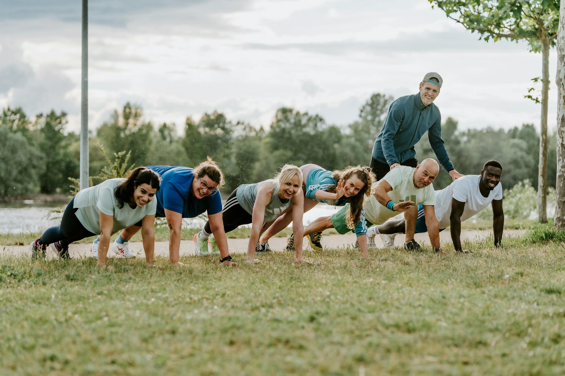 Outdoor Fitness Bootcamp Gruppe in der Plank-Position