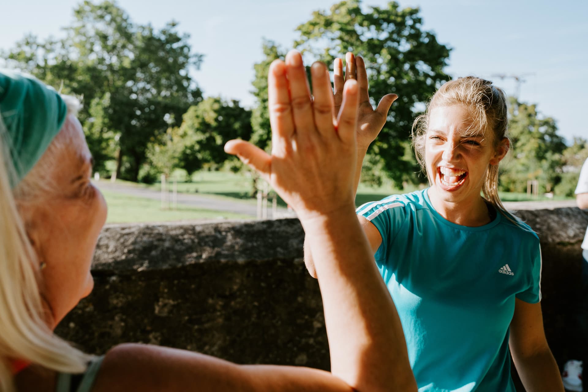 Gut gelaunte Personal Trainerin schlägt mit ihrer Teilnehmerin ein