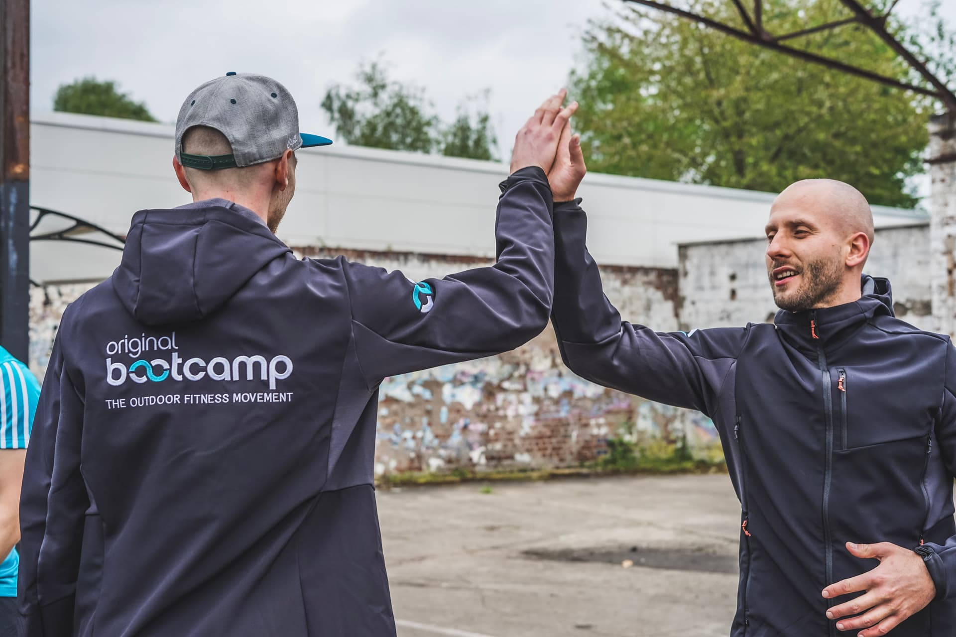 zwei männer in original Bootcamp Jacke gebe sich Highfive