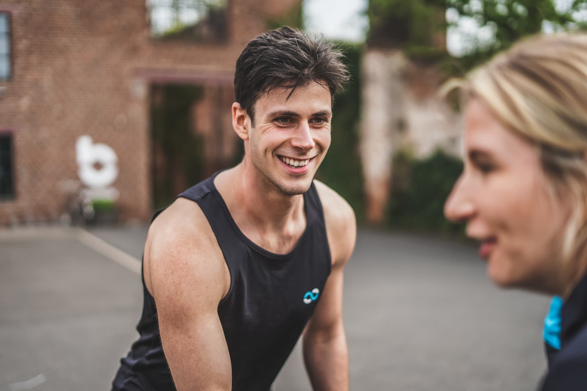 Personal Trainer Ben Boehm München lächelt eine Kollegin an