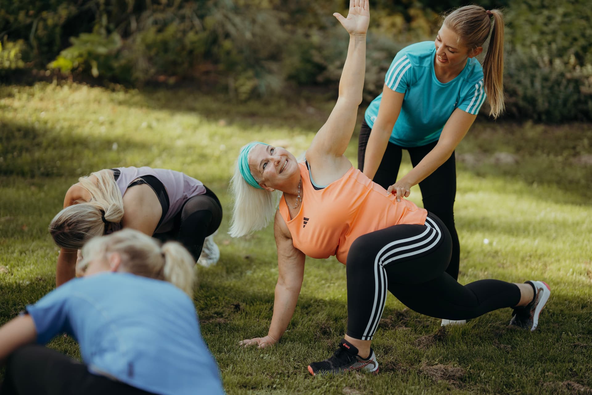 Eine Personal Trainerin vom Original Bootcamp korrigiert die Haltung einer Teilnehmerin