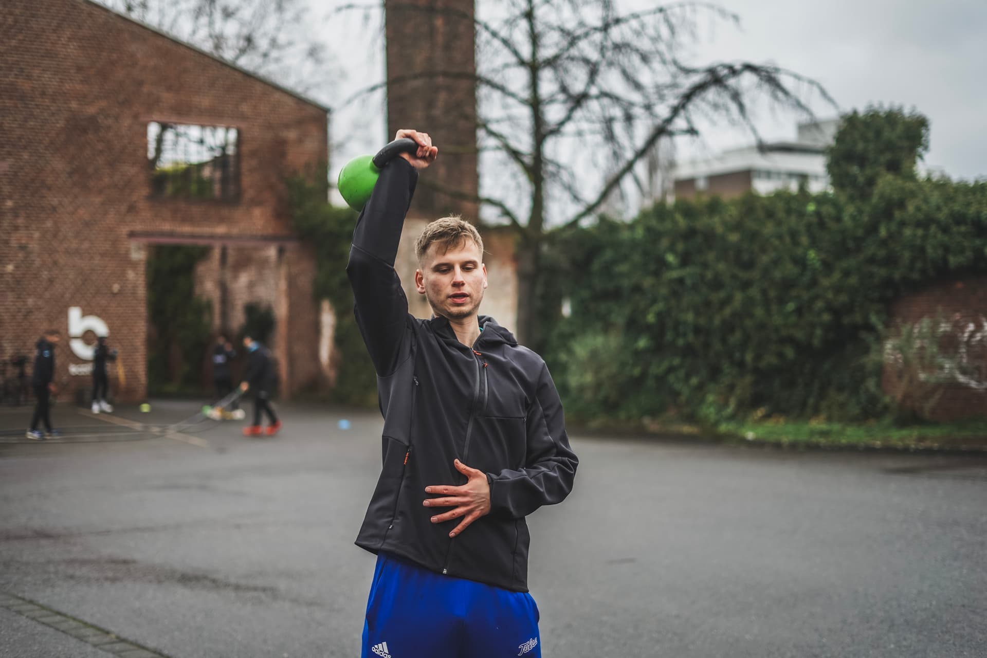 Personal Trainer hebt eine Kettlebell hoch