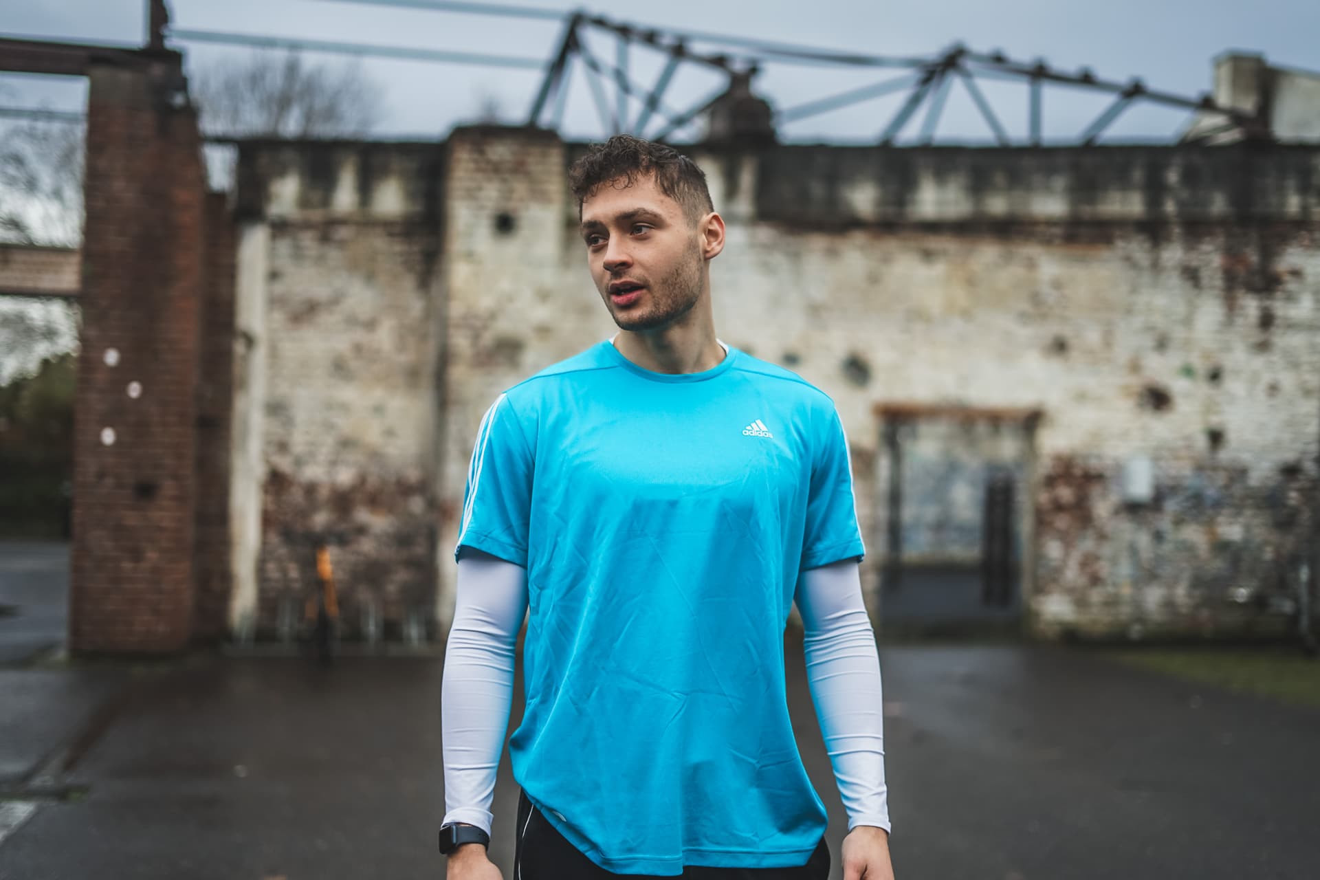 Max Höflich trägt ein türkisenes Bootcamp Shirt und erklärt eine Übung