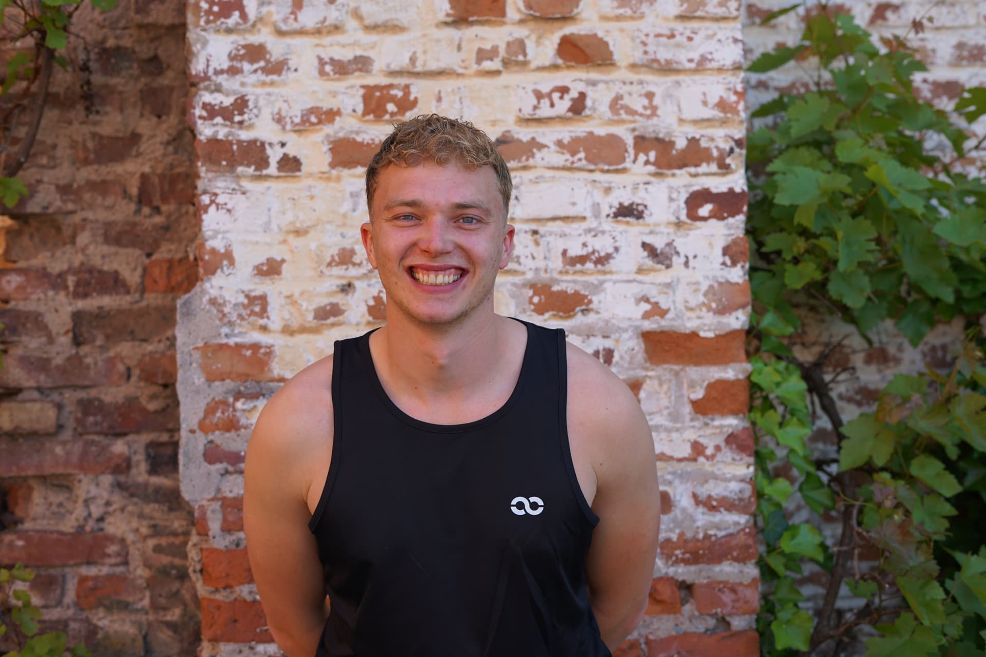 Mathies lächelt in die Kamera mit Hund auf seinem Schoß