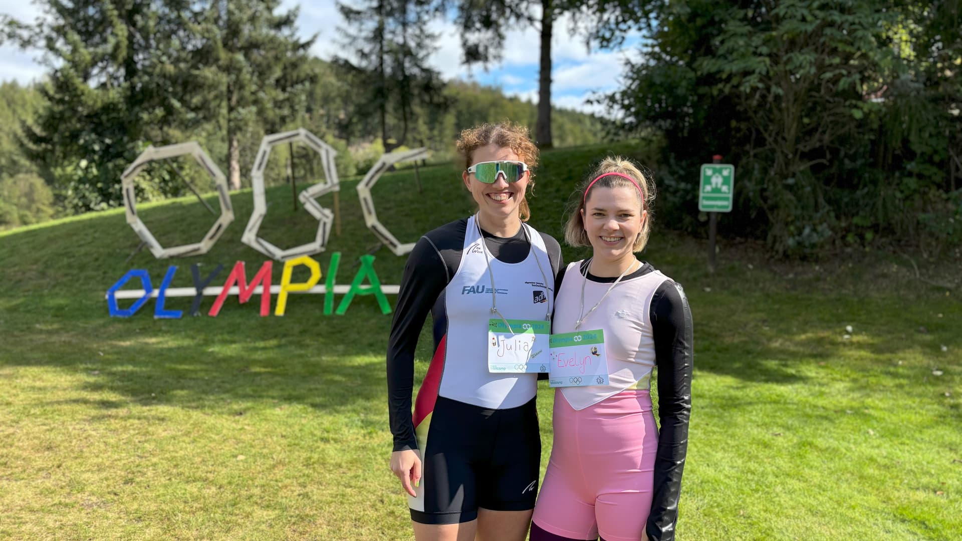 Personal Trainerin Evelyn Stoll aus Köln steht mit einer Trainerkollegin vor einem großen Original Bootcamp Logo