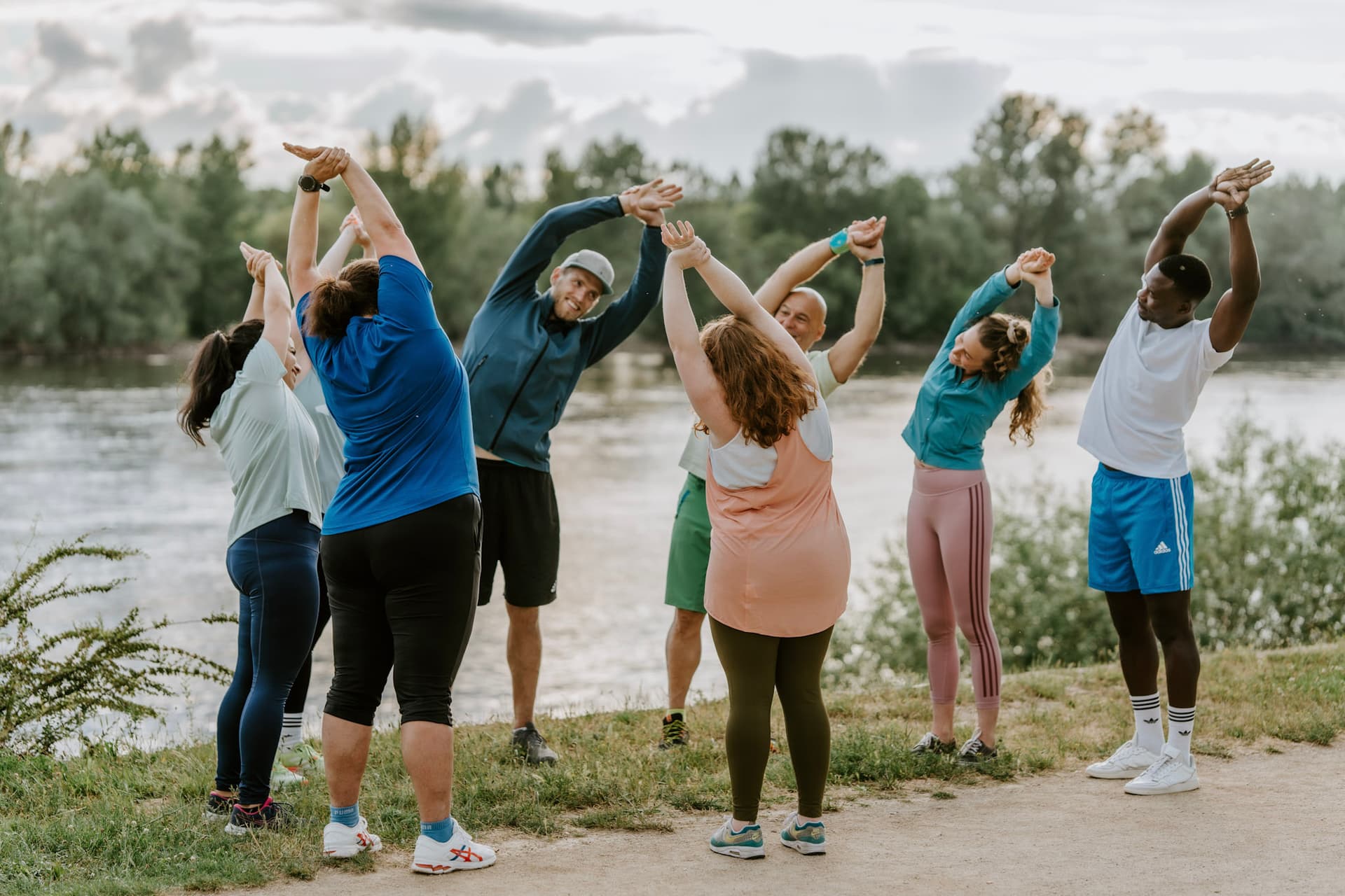 Dehnübung im Early Bird Outdoor Fitness Bootcamp am Morgen im Sommer im Park