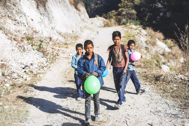 Vier Kinder spielen mit Luftballons in Nepal