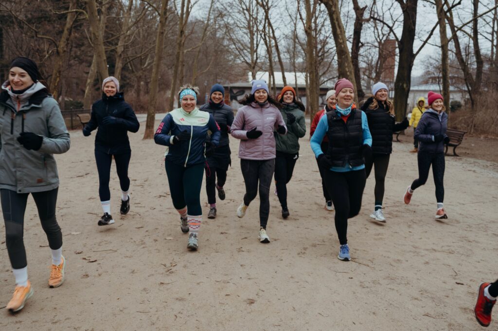 Geschenk für Sportler: Startplatz für einen Lauf Geschenk für Sportler: Laufgruppe joggt im Winter durch den Park