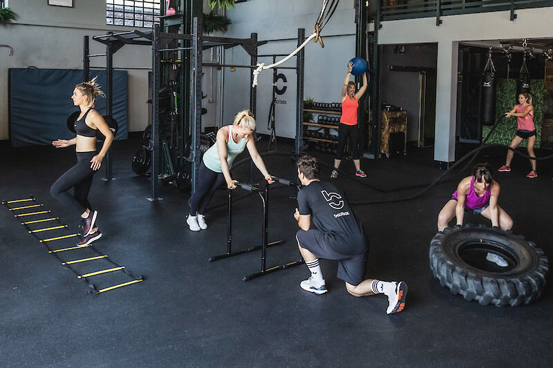 Zirkeltraining Übungen im Fitnessstudio mit Reifen, Kettlebell und Koordinationsleiter