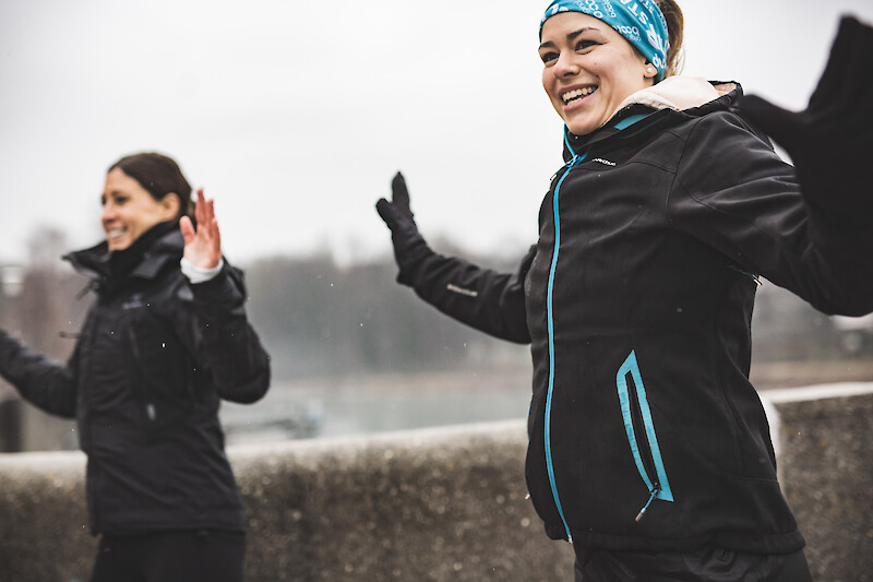 Outdoor winter training mit motiviertem Gruppentraining im Freien: Zwei Frauen absolvieren ein Outdoor-Fitness-Workout im Winter bei kalten Temperaturen