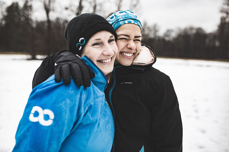 Outdoor Fitness M&uuml;nchen: Zwei Teilnehmerinnen lachen nach dem Training im Schnee.