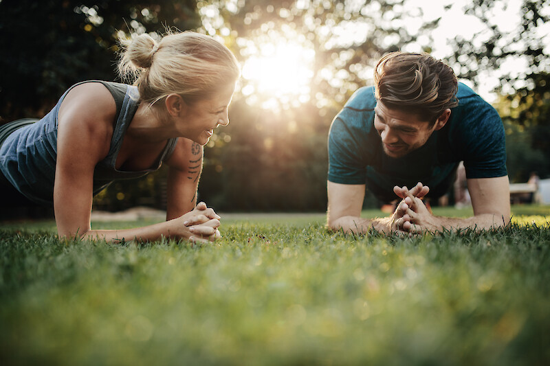 Outdoor Fitness München: Core-Workout im Park bei Sonnenlicht.
